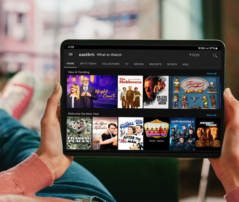 Person lying back on a sofa while using the TiVo Stream app on their iPad.